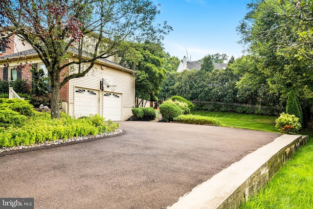 garage with fence and aphalt driveway