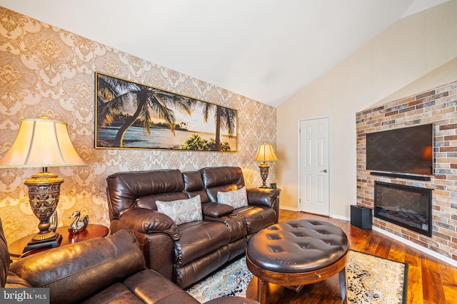 living room featuring lofted ceiling, a fireplace, wood finished floors, and baseboards