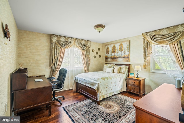 bedroom with hardwood / wood-style floors and wallpapered walls