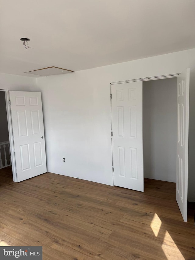 unfurnished bedroom with a closet and wood finished floors