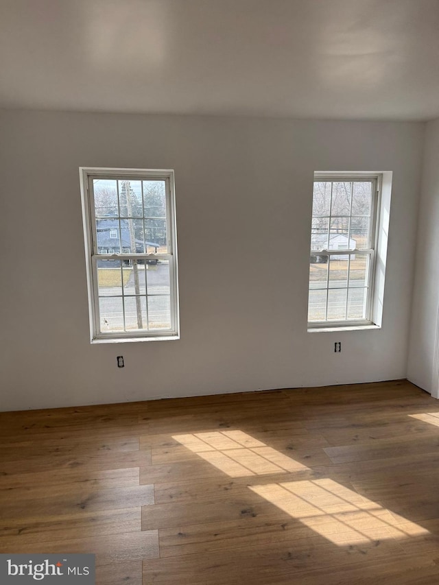 unfurnished room with a wealth of natural light and wood finished floors