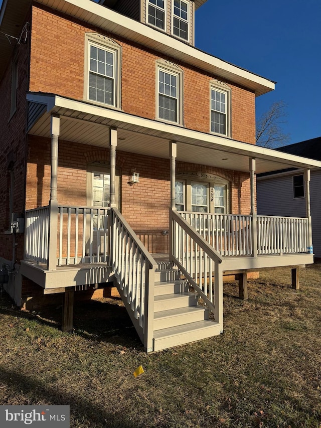 view of front of house with a porch and brick siding