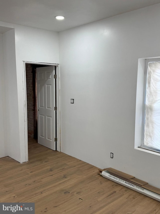 empty room with wood finished floors and recessed lighting