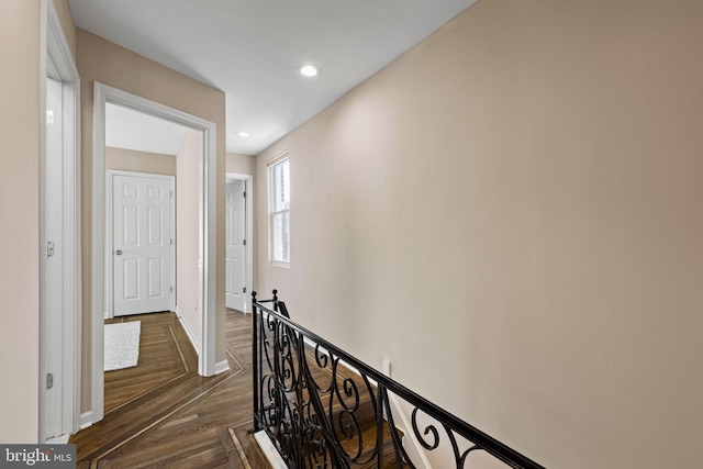 hall featuring an upstairs landing, recessed lighting, baseboards, and dark wood-style flooring