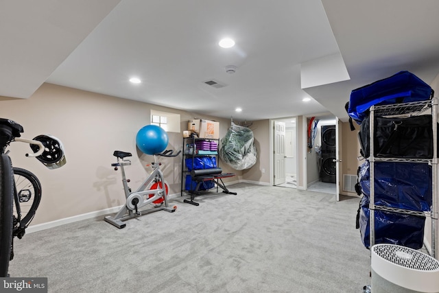 exercise area featuring visible vents, recessed lighting, stacked washer / drying machine, and baseboards