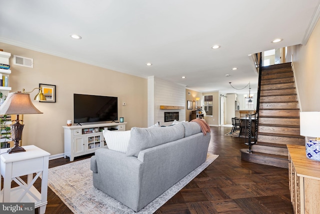 living area with stairway, visible vents, recessed lighting, ornamental molding, and a large fireplace