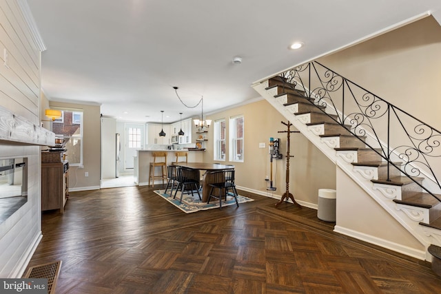 interior space with visible vents, stairway, crown molding, and baseboards