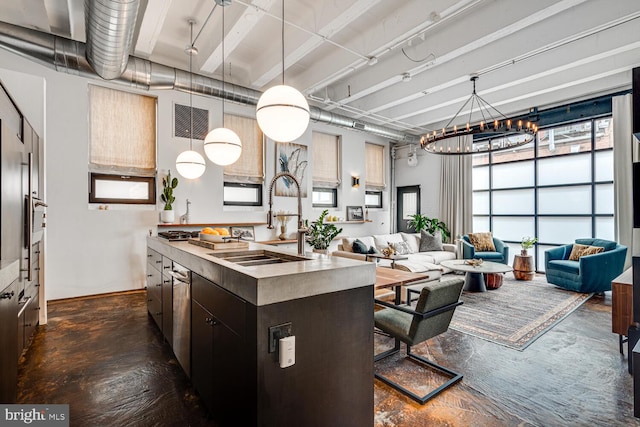 kitchen with visible vents, open floor plan, a center island, a sink, and a notable chandelier