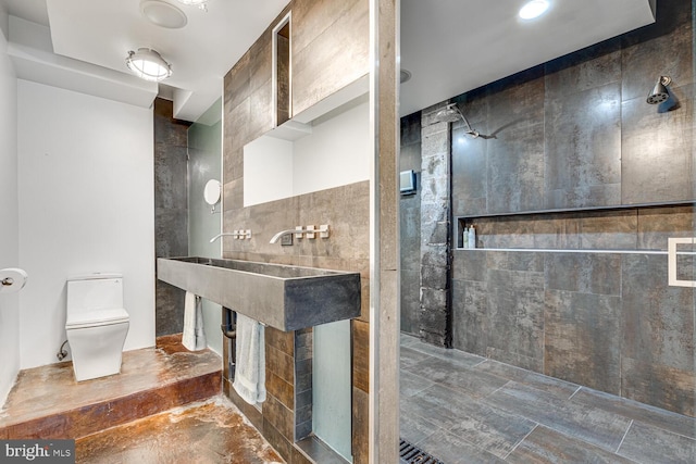 full bath featuring tiled shower and toilet