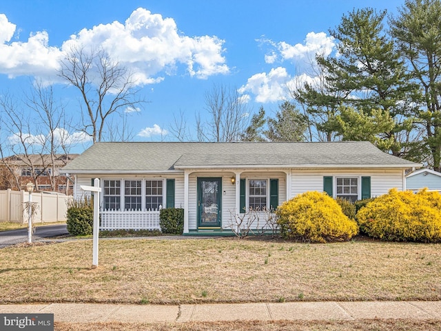 ranch-style house with a front yard and fence