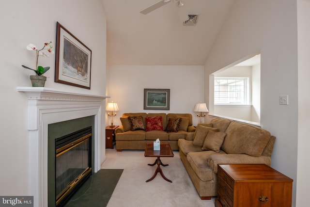 living area with visible vents, a ceiling fan, light colored carpet, lofted ceiling, and a fireplace with flush hearth