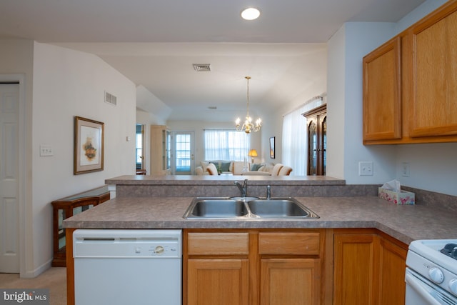 kitchen featuring a peninsula, white appliances, a sink, and visible vents