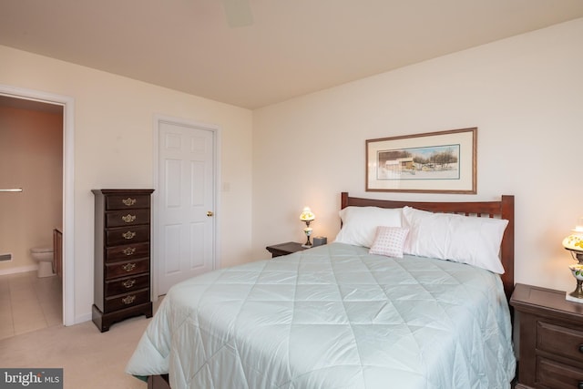 bedroom with ceiling fan, baseboards, connected bathroom, and light colored carpet