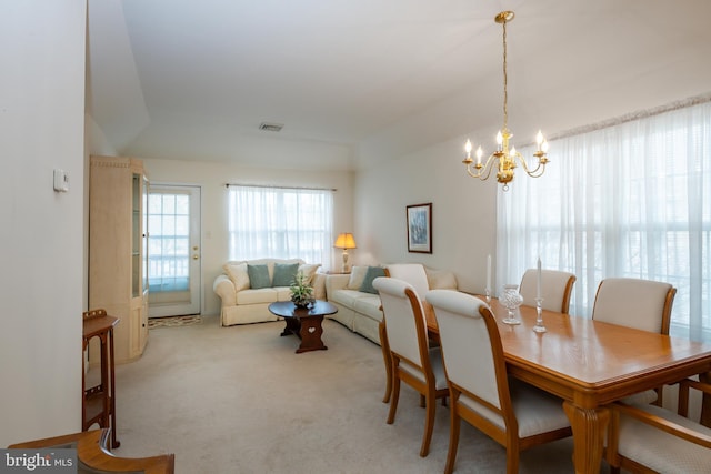 dining room with visible vents, a notable chandelier, and light colored carpet