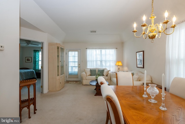 dining area featuring light carpet, visible vents, and an inviting chandelier