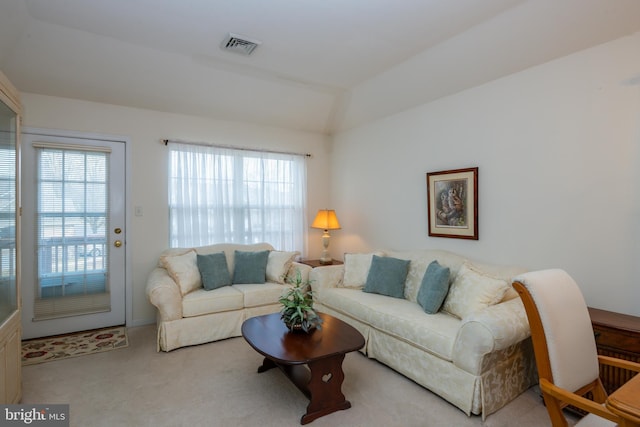 carpeted living room featuring lofted ceiling and visible vents