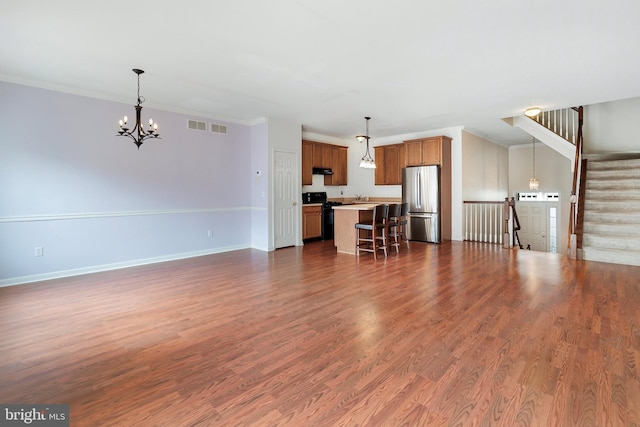 unfurnished living room with baseboards, visible vents, ornamental molding, stairs, and dark wood-type flooring