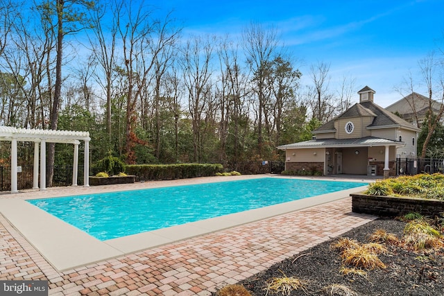 view of swimming pool featuring a patio, a fenced in pool, fence, a pergola, and a storage structure