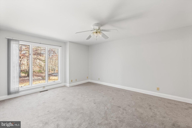 unfurnished room with carpet floors, baseboards, and a ceiling fan