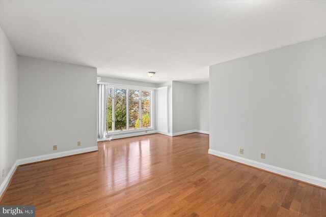 spare room featuring wood finished floors and baseboards