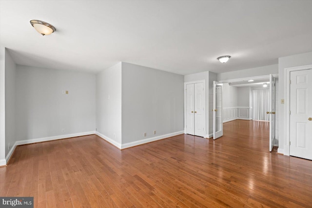 unfurnished room featuring baseboards and hardwood / wood-style flooring