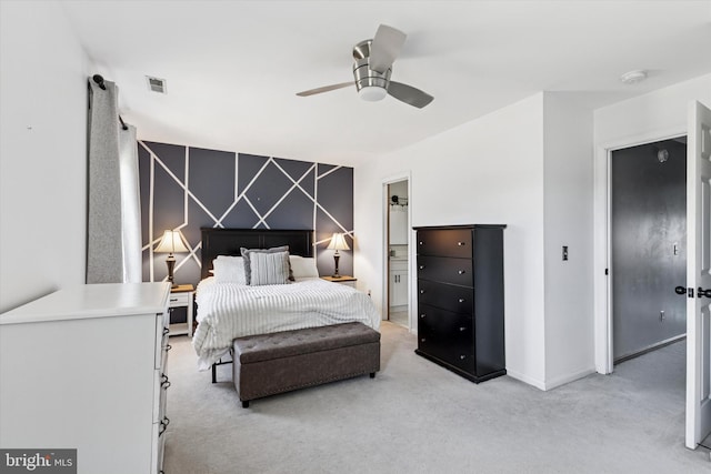 bedroom featuring visible vents, an accent wall, light carpet, ceiling fan, and baseboards