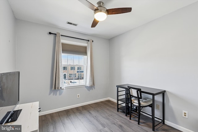 home office featuring a ceiling fan, baseboards, visible vents, and wood finished floors