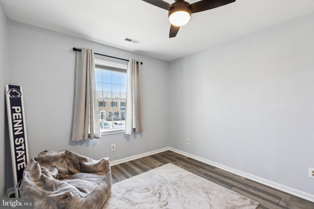 living area featuring ceiling fan, visible vents, dark wood finished floors, and baseboards