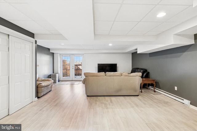 living area featuring french doors, a drop ceiling, baseboard heating, and wood finished floors