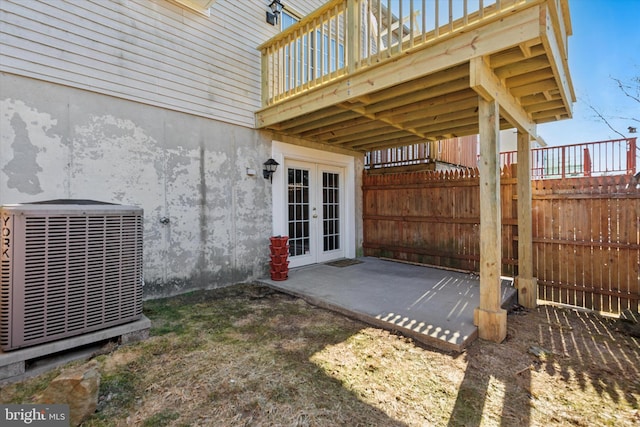 view of patio / terrace featuring fence, central AC unit, and french doors