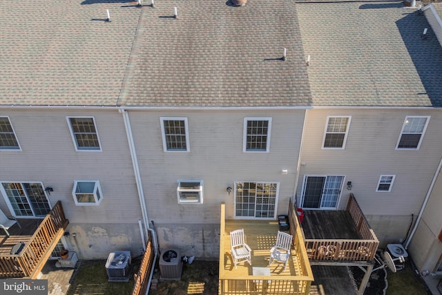 back of property featuring a shingled roof and central AC unit