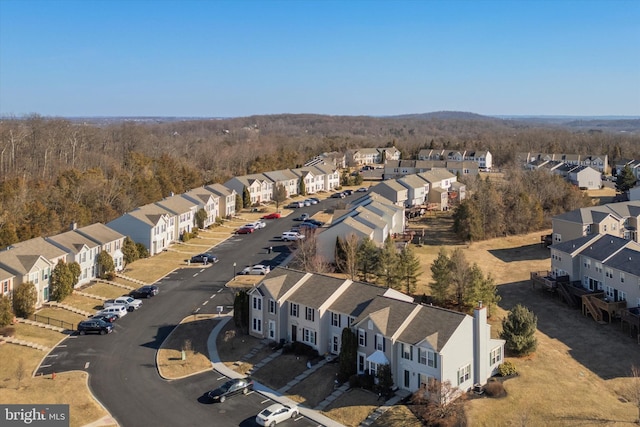 drone / aerial view featuring a residential view and a forest view