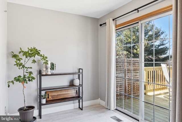 entryway featuring wood finished floors, visible vents, and baseboards