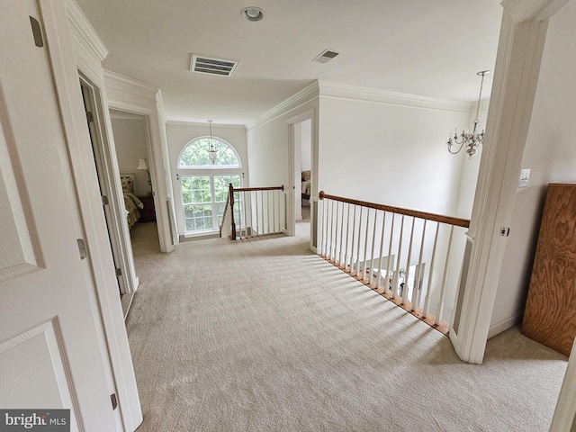 corridor with visible vents, ornamental molding, carpet flooring, an upstairs landing, and a notable chandelier