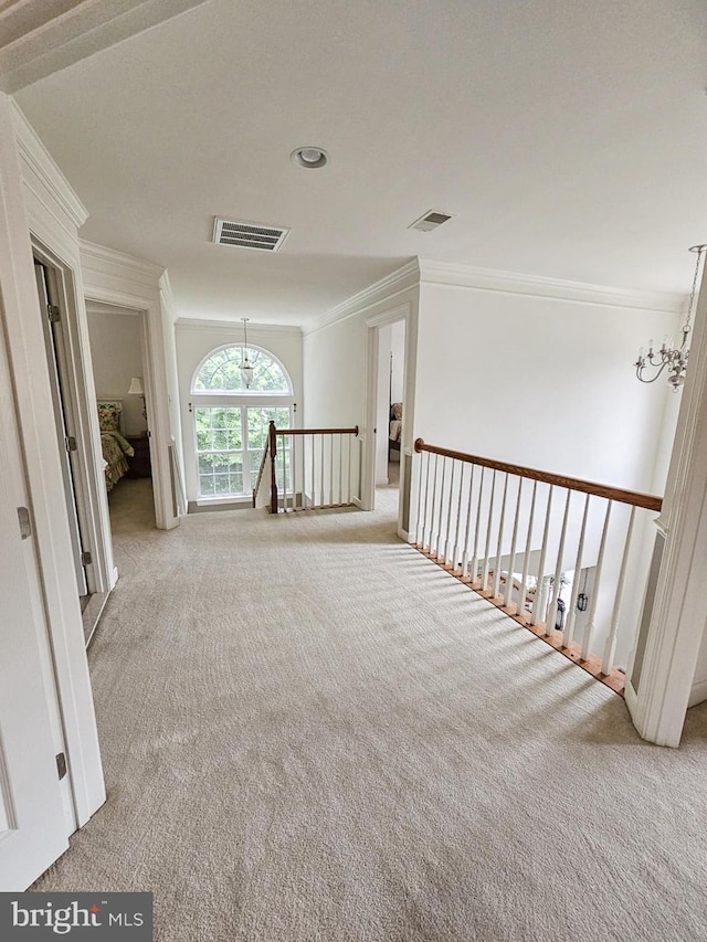 corridor with carpet, visible vents, crown molding, and an upstairs landing