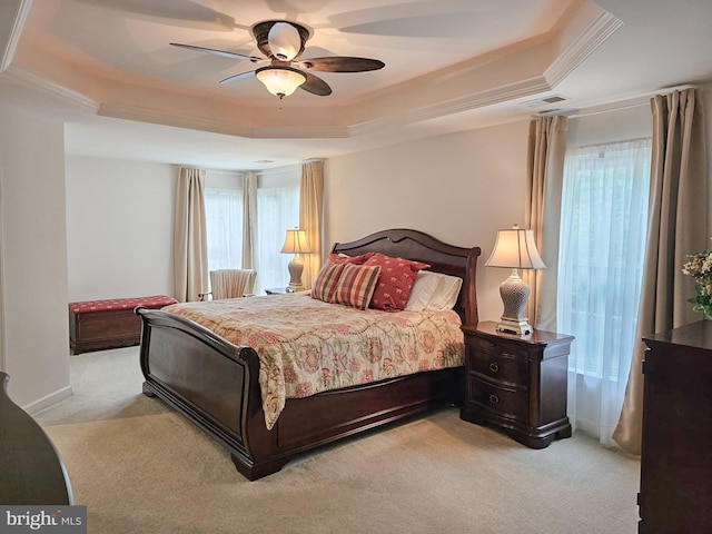 bedroom featuring visible vents, a raised ceiling, and light colored carpet