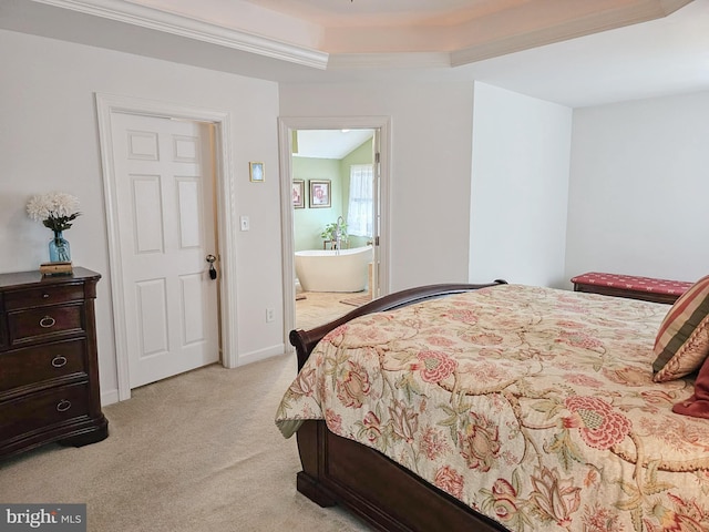 bedroom featuring baseboards, ensuite bath, and light colored carpet