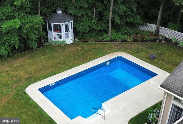 view of swimming pool with a gazebo, fence, and a yard