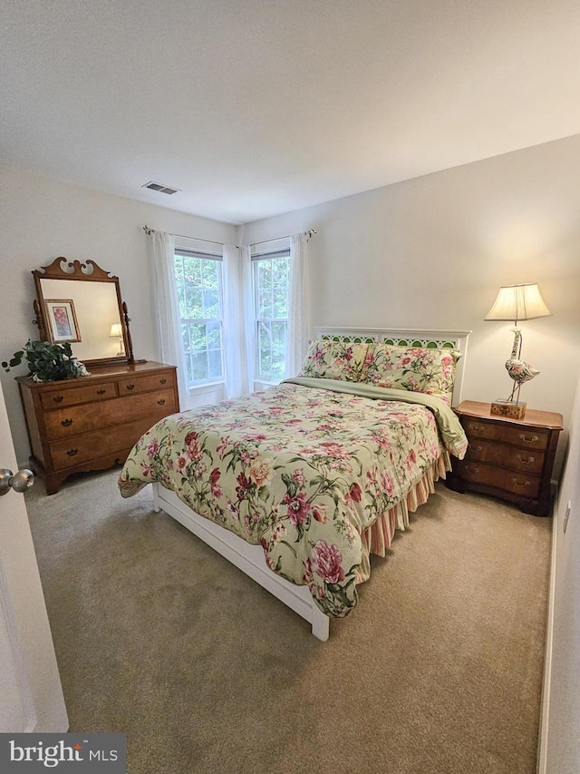 carpeted bedroom featuring visible vents