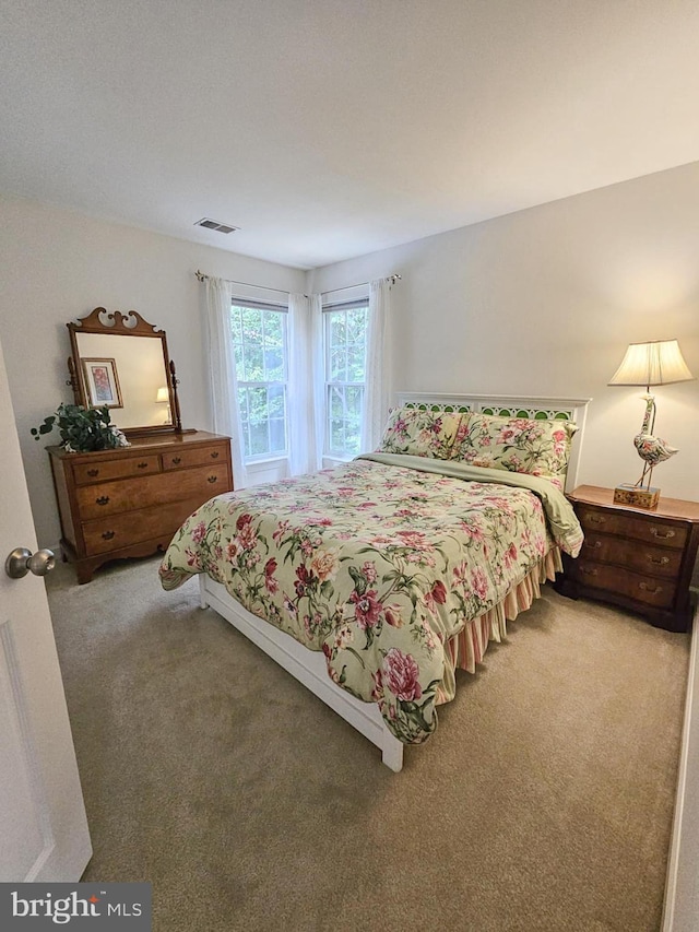 carpeted bedroom featuring visible vents