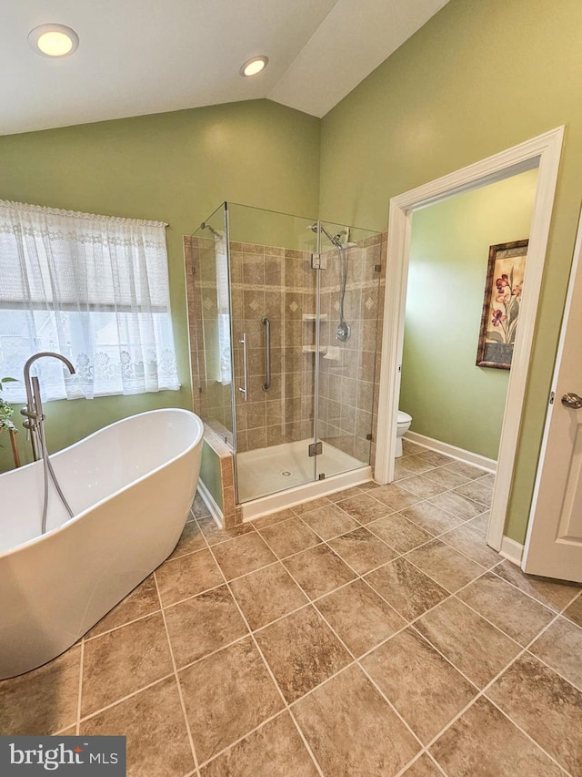 full bath featuring a stall shower, toilet, tile patterned floors, vaulted ceiling, and a freestanding bath