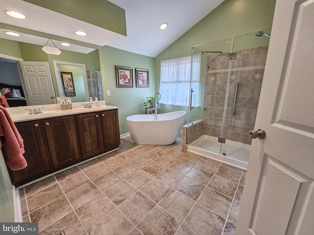 full bathroom featuring double vanity, a stall shower, vaulted ceiling, and a soaking tub