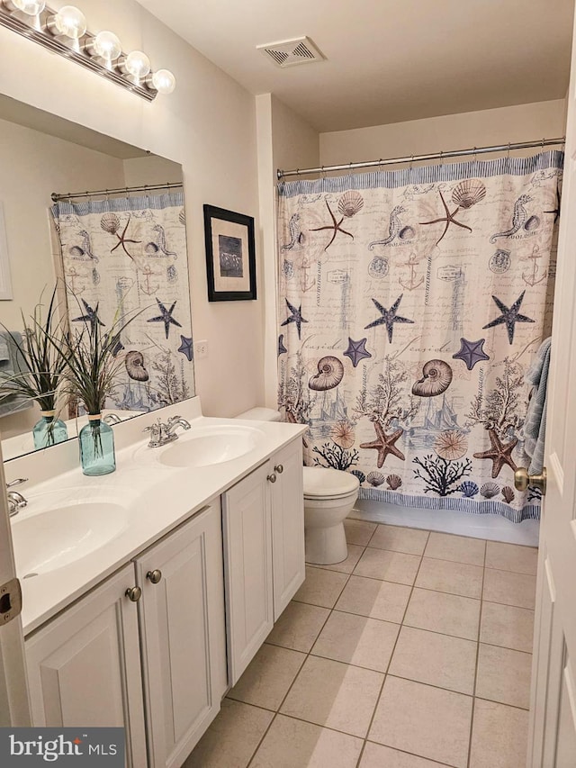 bathroom with toilet, a sink, visible vents, tile patterned floors, and double vanity