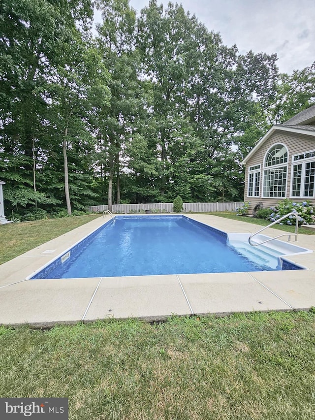 view of swimming pool featuring a fenced in pool, a patio area, a yard, and fence