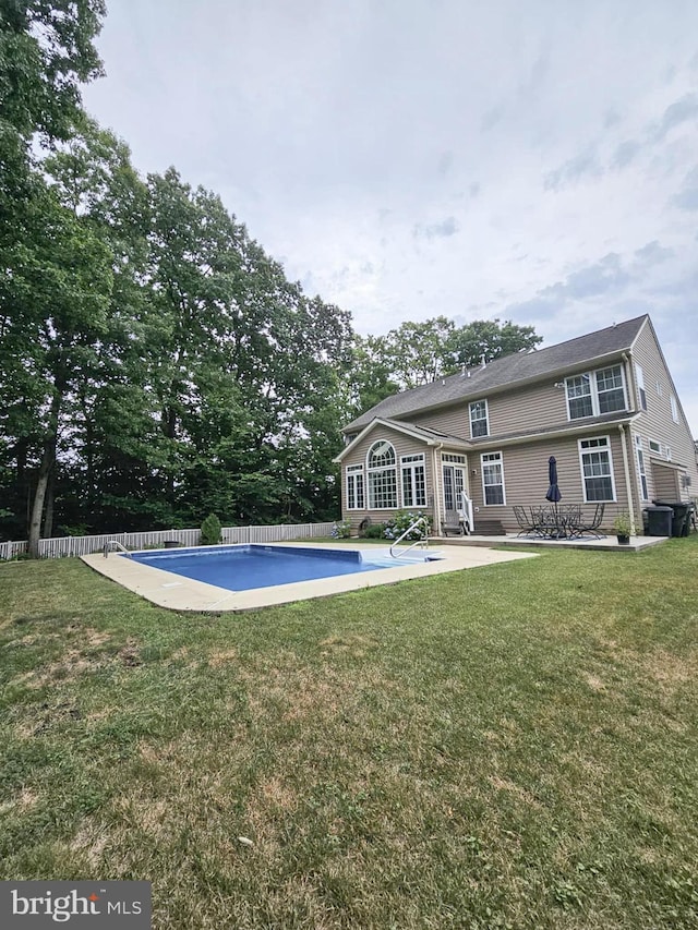 view of swimming pool featuring a fenced in pool, fence, a lawn, and a patio