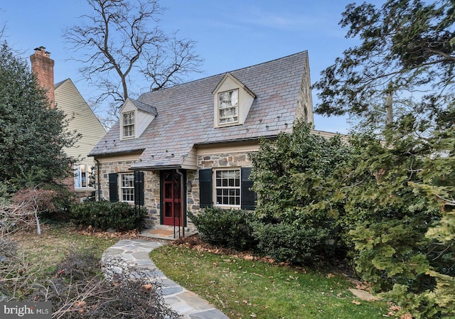 view of front of house with a high end roof, a chimney, and stone siding