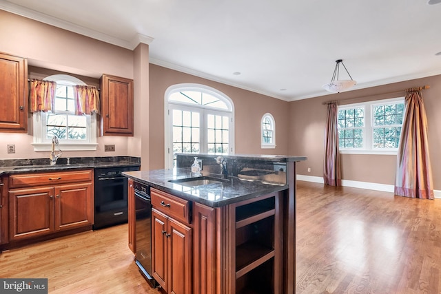 kitchen featuring light wood-style flooring, brown cabinetry, and a sink