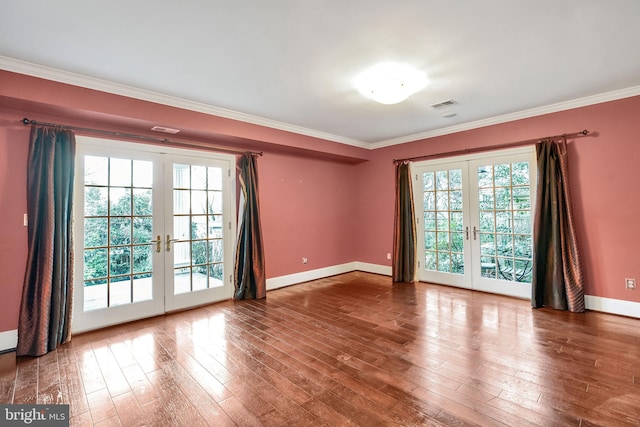 empty room with crown molding, french doors, visible vents, and wood-type flooring