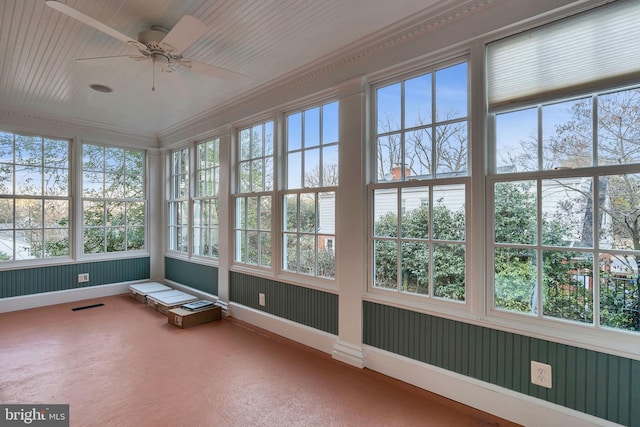 unfurnished sunroom featuring a ceiling fan, visible vents, and a wealth of natural light