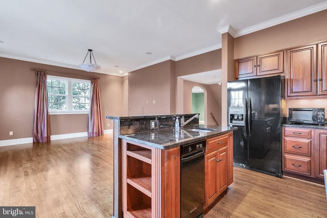 kitchen with baseboards, ornamental molding, light wood-style flooring, black refrigerator with ice dispenser, and a sink